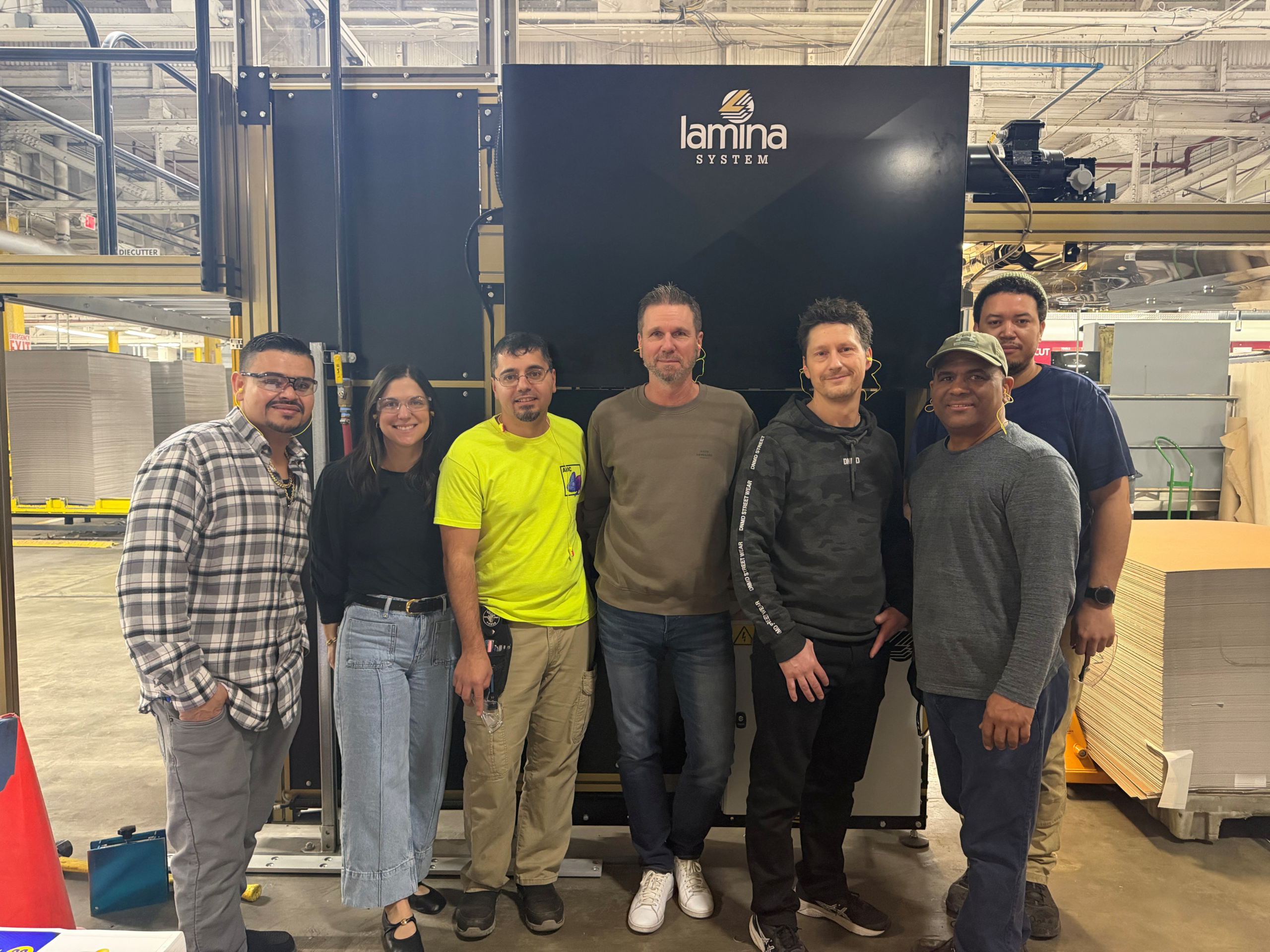 Accurate Box and Lamina machine teams pictured in front of machine
