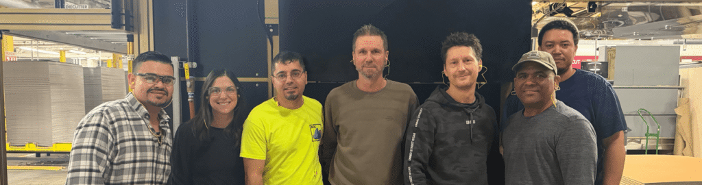 Accurate Box and Lamina machine teams pictured in front of machine